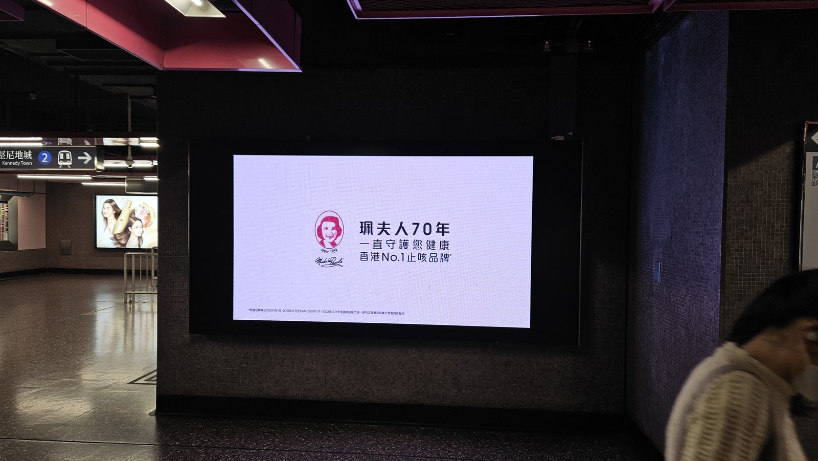 Madame Pearl's cough-syrup product creative on an MTR digital panel, Causeway Bay